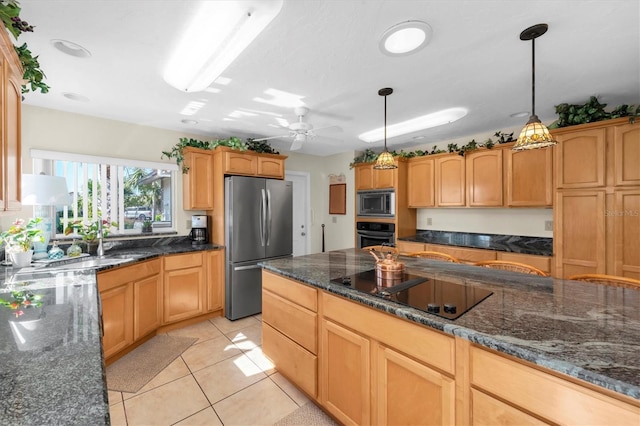 kitchen with hanging light fixtures, light tile patterned flooring, appliances with stainless steel finishes, and dark stone countertops