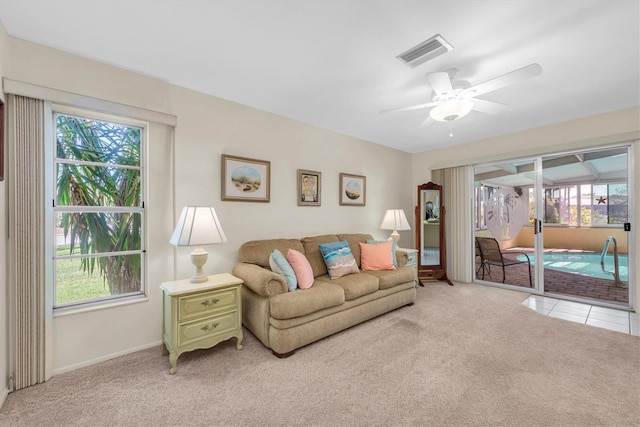 living room with a healthy amount of sunlight, light carpet, and ceiling fan