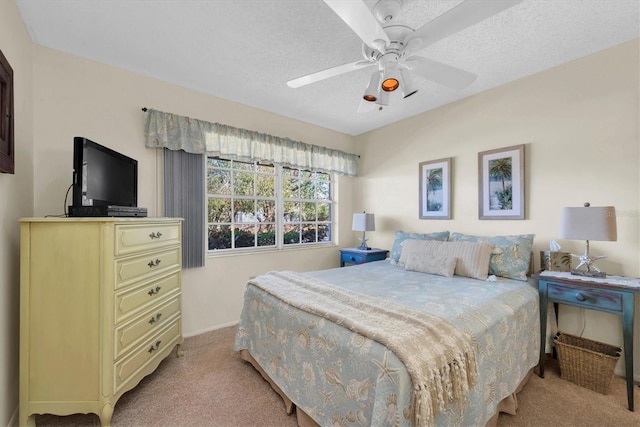 carpeted bedroom featuring ceiling fan and a textured ceiling