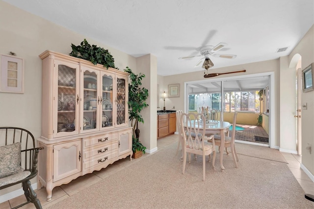 dining space featuring visible vents, a ceiling fan, a sunroom, light tile patterned floors, and baseboards