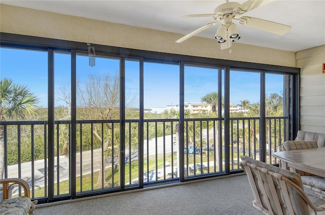 sunroom / solarium with plenty of natural light and ceiling fan