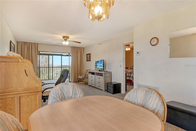 dining area with ceiling fan with notable chandelier, light carpet, and a textured ceiling