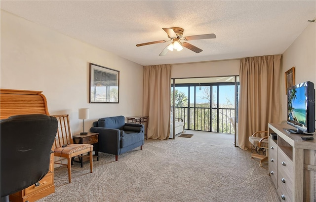 sitting room with light carpet, ceiling fan, and a textured ceiling