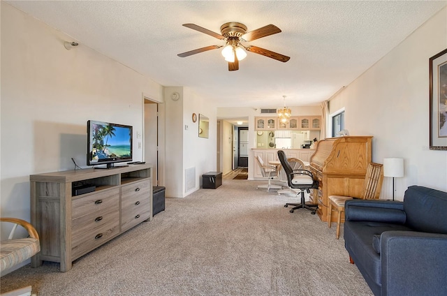 interior space with ceiling fan, light carpet, and a textured ceiling