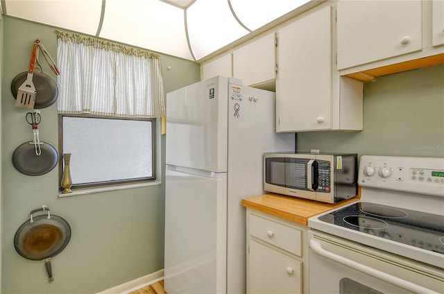 kitchen featuring white appliances and white cabinets