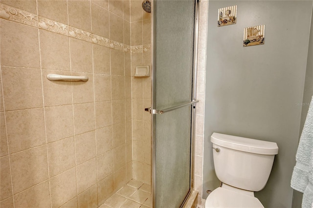 bathroom with a shower with door and toilet