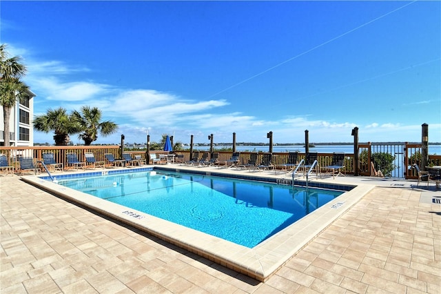 view of pool featuring a patio area and a water view