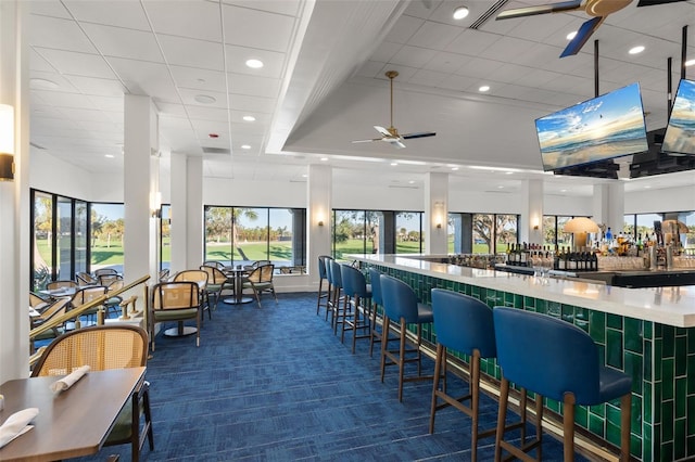 bar featuring dark carpet and ceiling fan