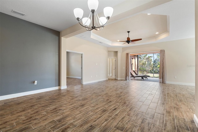 interior space featuring hardwood / wood-style flooring, a raised ceiling, and ceiling fan with notable chandelier