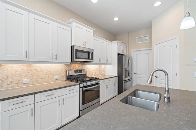 kitchen with sink, white cabinetry, tasteful backsplash, appliances with stainless steel finishes, and pendant lighting