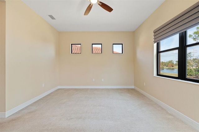 empty room featuring light colored carpet and ceiling fan