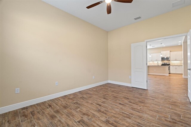 spare room with ceiling fan and light hardwood / wood-style flooring