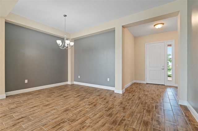 foyer entrance with hardwood / wood-style flooring and a chandelier