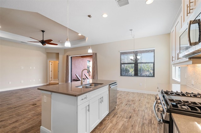 kitchen with white cabinetry, stainless steel appliances, sink, and hanging light fixtures