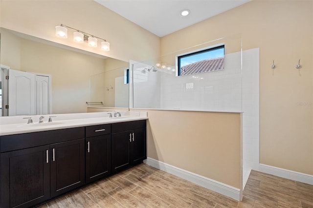 bathroom featuring tiled shower and vanity