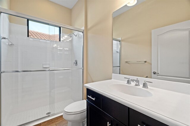 bathroom with vanity, an enclosed shower, and toilet