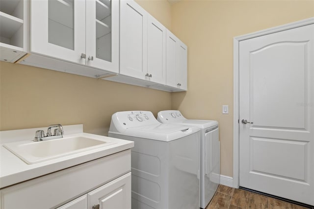 laundry area with dark hardwood / wood-style flooring, cabinets, sink, and independent washer and dryer