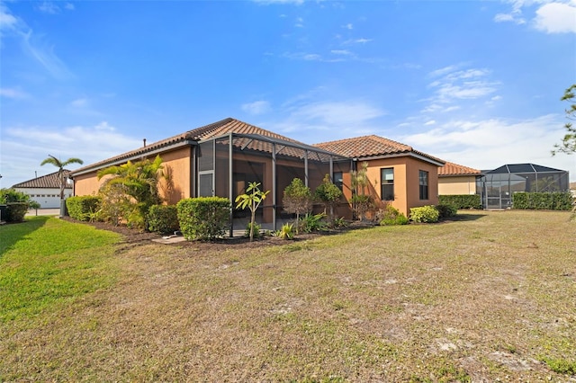 rear view of property with a lanai and a lawn