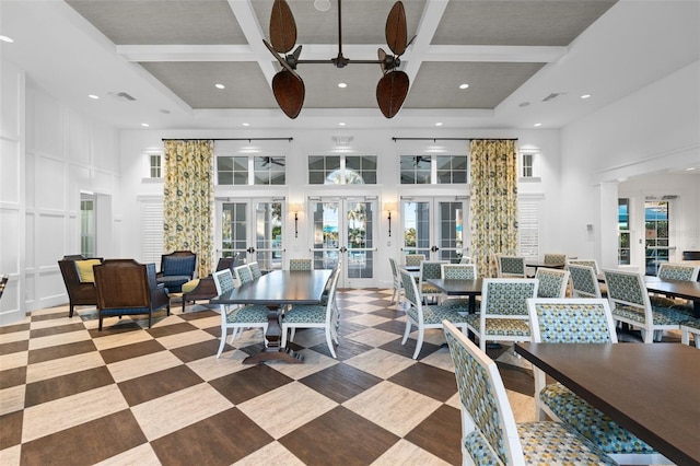 dining space featuring coffered ceiling, a towering ceiling, plenty of natural light, and french doors