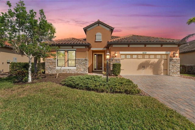 mediterranean / spanish-style house featuring a garage and a lawn