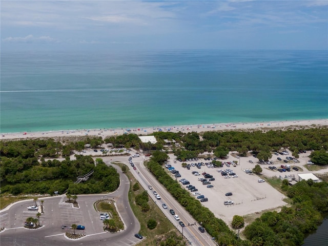 birds eye view of property with a water view and a beach view