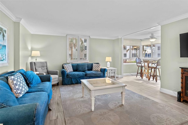 living room featuring crown molding, light hardwood / wood-style flooring, and ceiling fan