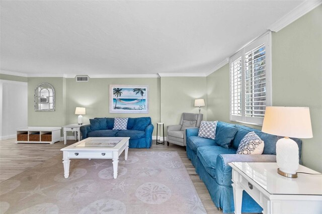 living room with crown molding and light wood-type flooring