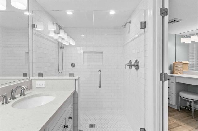 bathroom with an enclosed shower, hardwood / wood-style floors, and vanity