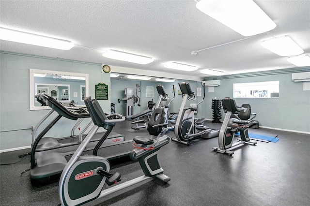 exercise room featuring a wall mounted air conditioner and a textured ceiling