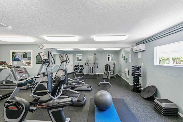 exercise room with a wall mounted AC and a textured ceiling