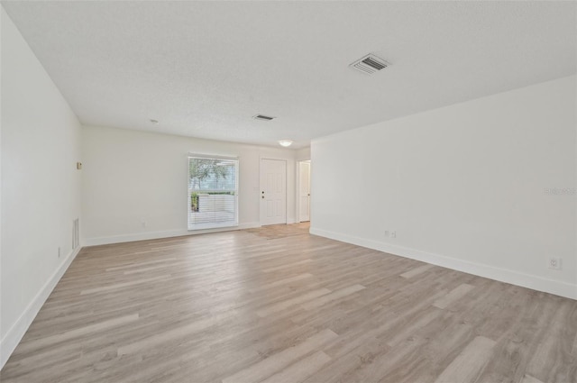 spare room featuring a textured ceiling and light wood-type flooring