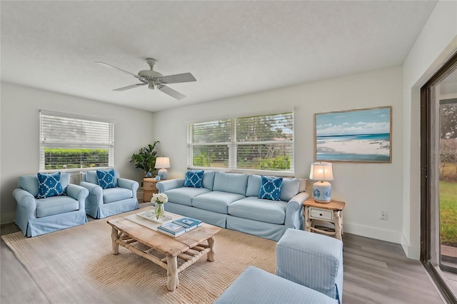 living room with ceiling fan, hardwood / wood-style flooring, and a textured ceiling