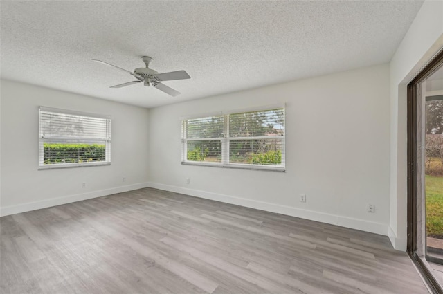 empty room with ceiling fan, a textured ceiling, and light wood-type flooring