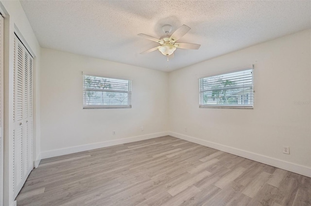 unfurnished bedroom featuring ceiling fan, light hardwood / wood-style flooring, a closet, and a textured ceiling