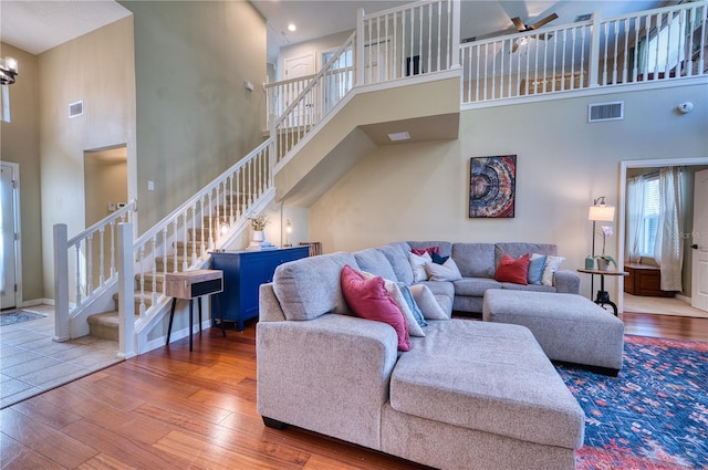 living room with hardwood / wood-style flooring and a towering ceiling