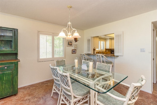 dining space with crown molding and an inviting chandelier