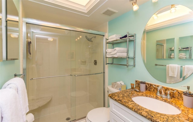 bathroom featuring a shower with door, vanity, and toilet