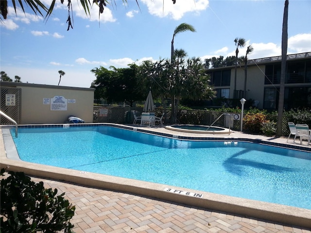 view of swimming pool featuring a hot tub