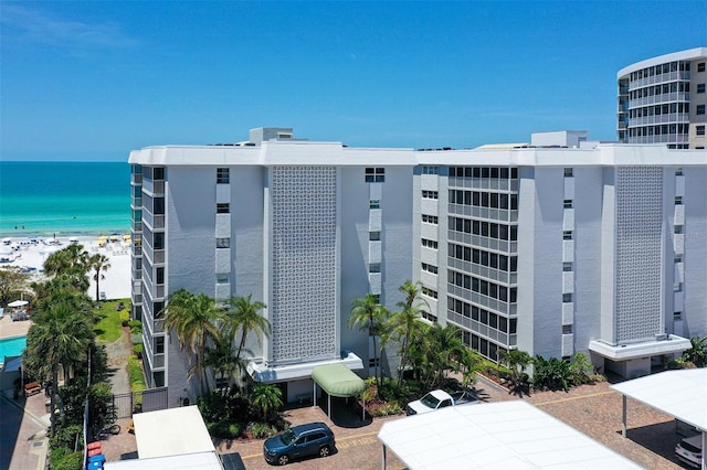 view of building exterior with a water view and a beach view