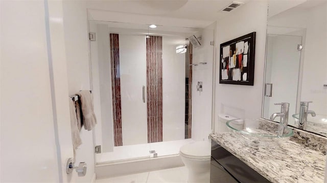 bathroom featuring vanity, a shower with door, and toilet