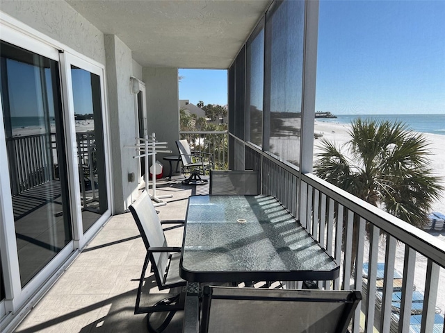 balcony featuring a water view and a view of the beach