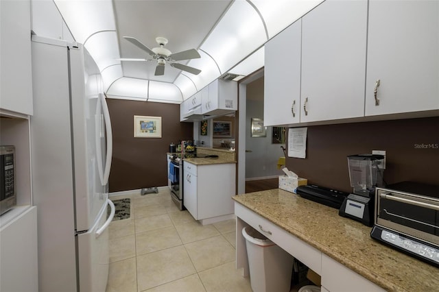 kitchen featuring light tile patterned flooring, appliances with stainless steel finishes, white cabinets, light stone counters, and ceiling fan