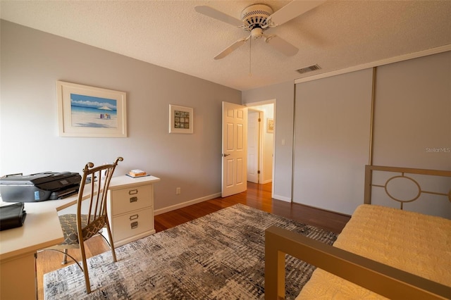 office area featuring ceiling fan, a textured ceiling, and dark hardwood / wood-style flooring