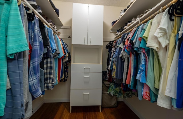 spacious closet with dark hardwood / wood-style flooring