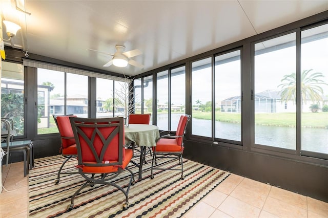 sunroom with a water view, plenty of natural light, and ceiling fan