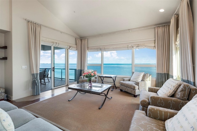 living room featuring hardwood / wood-style floors, a wealth of natural light, vaulted ceiling, and a water view