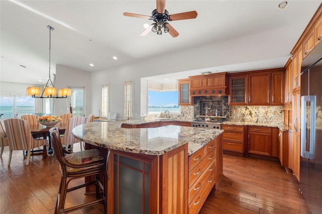 kitchen with a kitchen bar, dark hardwood / wood-style floors, sink, and a kitchen island