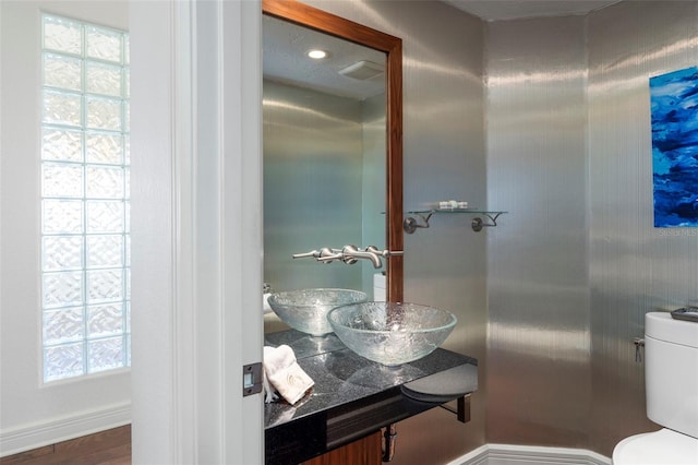 bathroom featuring sink, a wealth of natural light, and toilet