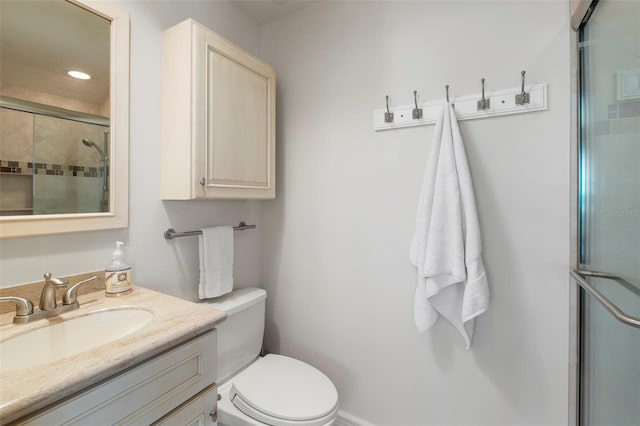 bathroom with an enclosed shower, vanity, and toilet