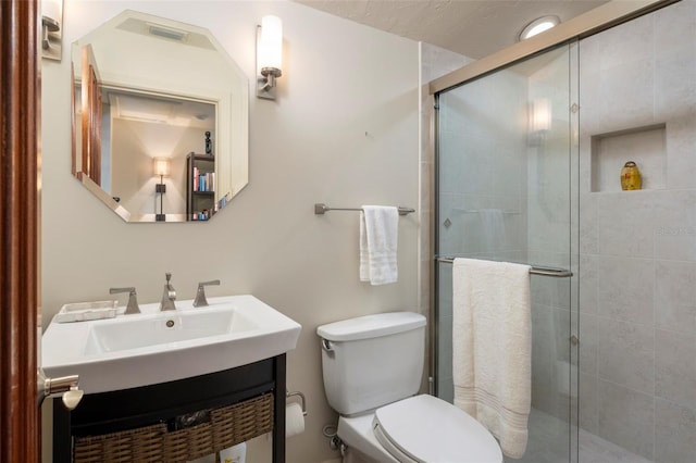 bathroom featuring walk in shower, vanity, and toilet